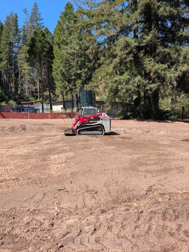Skid steer smoothing the initial shaping on the 17th green