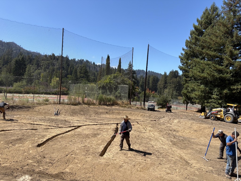 Crew working trenches in a herringbone pattern on a shaped green