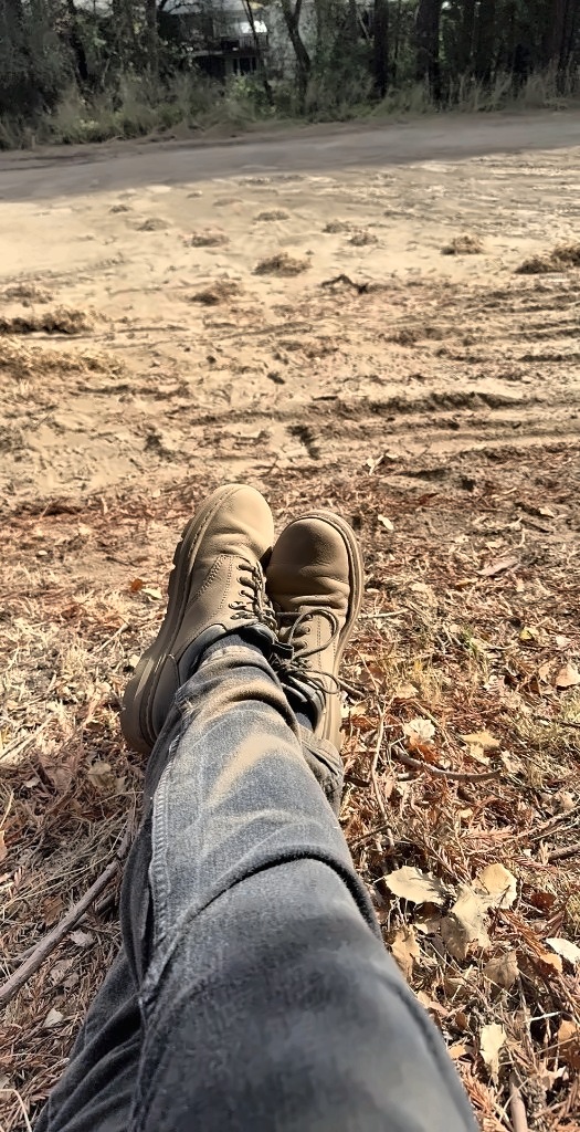 Arnold's boots up on a bed of redwood needles, looking out over the raked 17th fairway dotted with rake piles