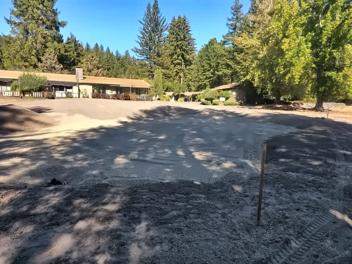 The 10th green with fresh sand going down, the clubhouse and cottages behind it
